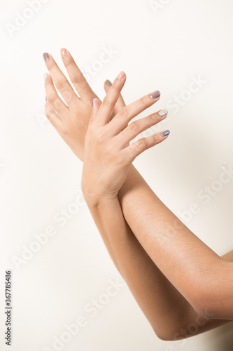 woman hands applying moisturizing cream to her skin on a white background