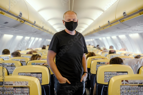 Man in protective mask standing in the airplane