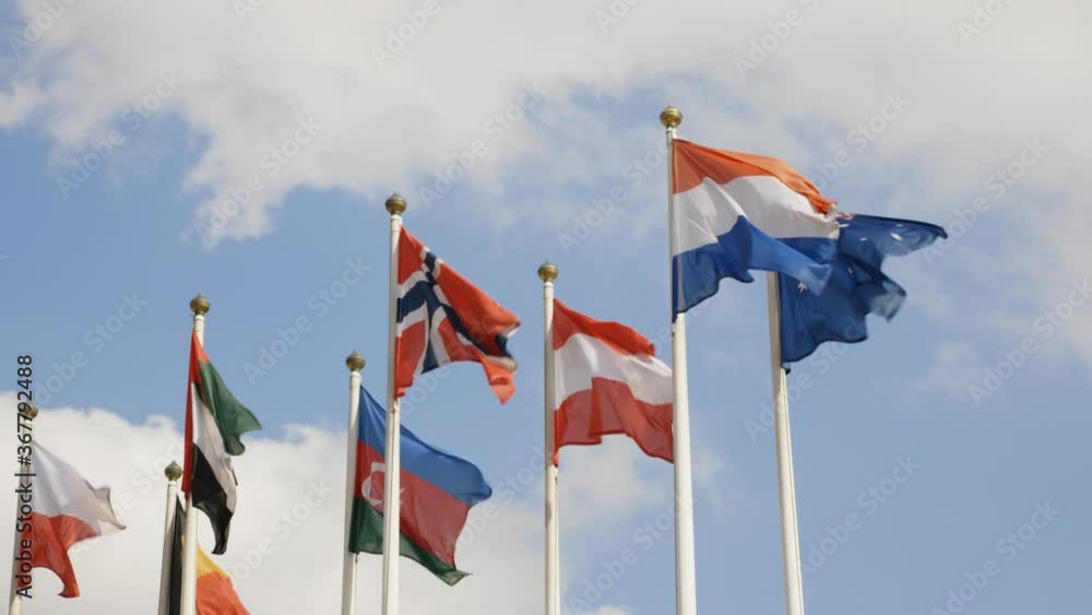 Various national flags with the EU flag under a blue sky. Various national flags with the EU flag under a blue sky.