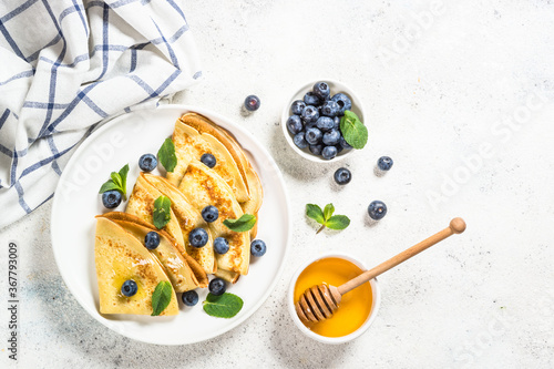 Crepes with blueberries at white table. photo