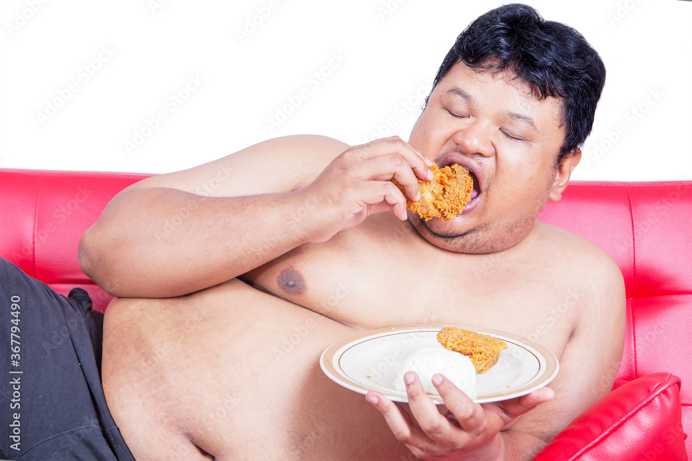 Close up of an obesity man eating chicken on studio Close up of an obesity man eating chicken on studio