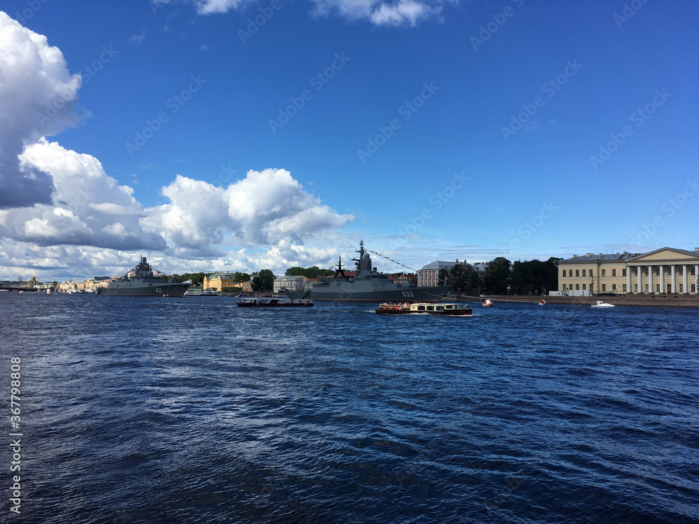 Fototapeta premium Warships in the water area of ​​the Neva, arrived to participate in the naval parade in St. Petersburg, and pleasure boats with tourists.