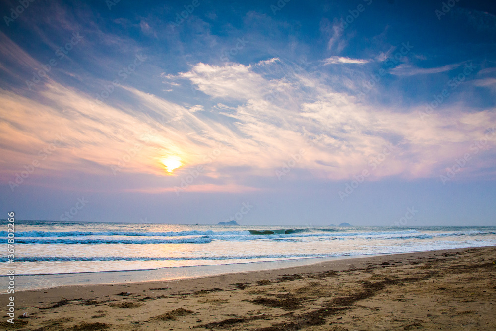 Sun is fall down sunset with sea and beach and waving clear sky Sun is fall down sunset with sea and beach and waving clear sky