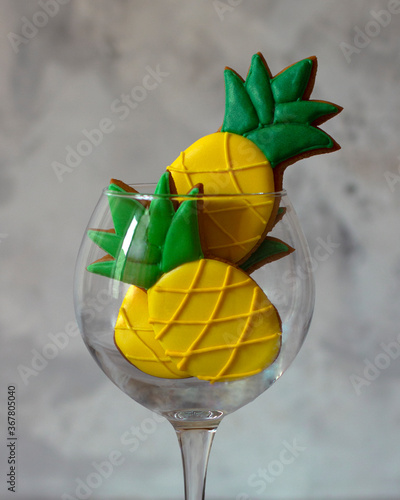 Gingerbread pineapples in a glass glass on a neutral background with a copy space. Modern non-standard style