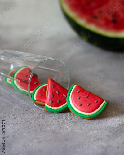 Gingerbread falling out of a glass glass on a neutral background. Gingerbread watermelon slices. Cut watermelon in the background