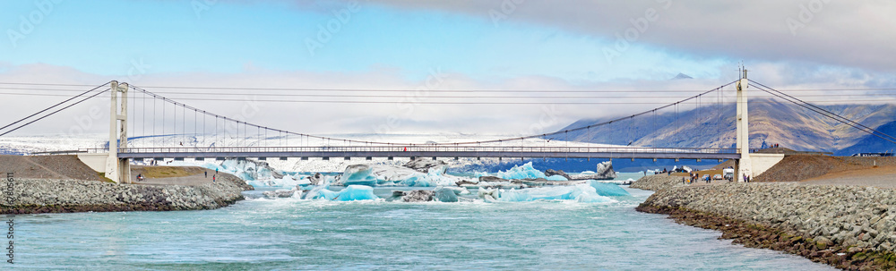 JOKULSARLON, ICELAND: Suspension bridge of National Route No 1 crossing the outlet of Jokulsarlon glacier lagoon with its floating icebergs.