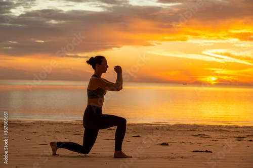 Woman doing split squats on the beach