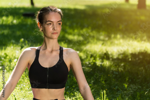 stylish young girl in sports fitness clothes, against the backdrop of a green park on a fresh cheer ©  drugoenebo