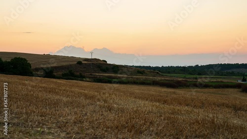 Wallpaper Mural Time-lapse of sunrise amidst low clouds. The sky lights up orange as the sun’s rays rise through the cloud. In the foreground, a field of freshly harvested wheat. Torontodigital.ca