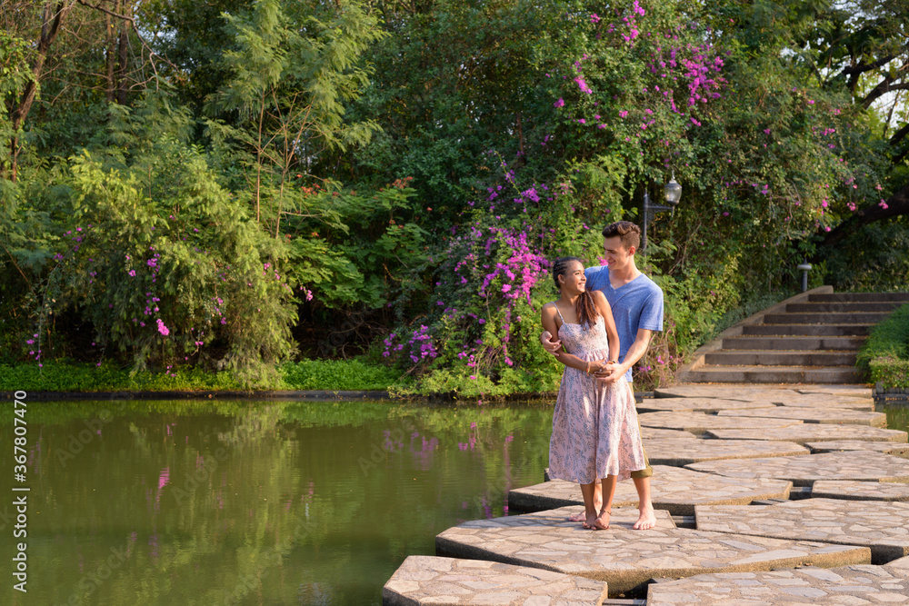 Portrait of young multi ethnic couple relaxing together at the park Portrait of young multi ethnic couple relaxing together at the park