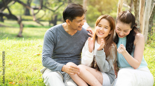 Asian family are happy to picnic  do the lifestyle of parent and daughter in the park. Learn about nature during the long summer holidays with good weather. Concept Health insurance COVID-19