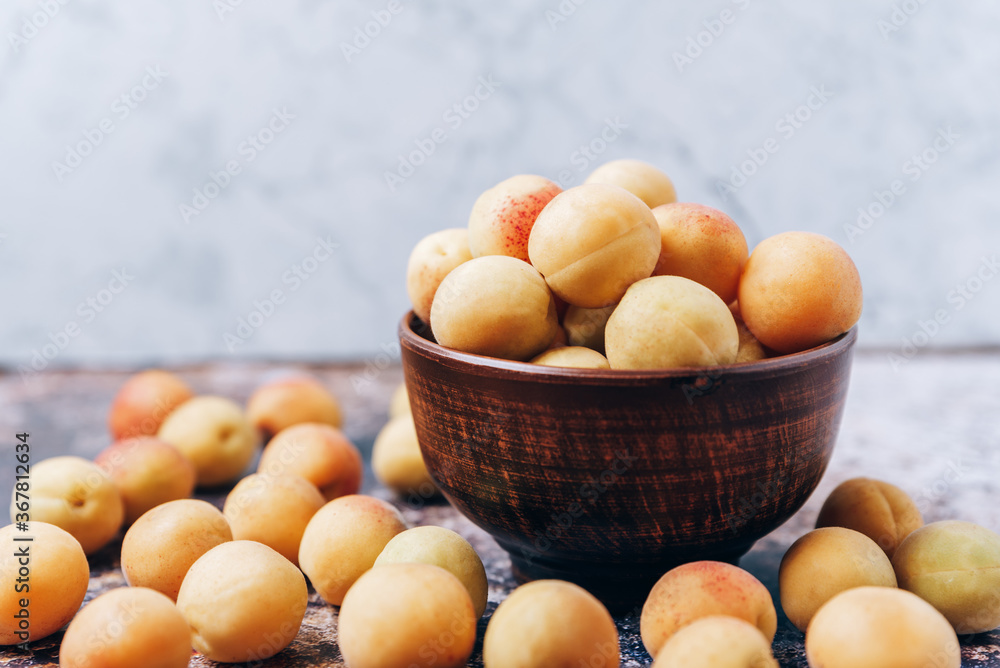 Lots of ripe yellow apricots close up in a crockery on the table Lots of ripe yellow apricots close up in a crockery on the table