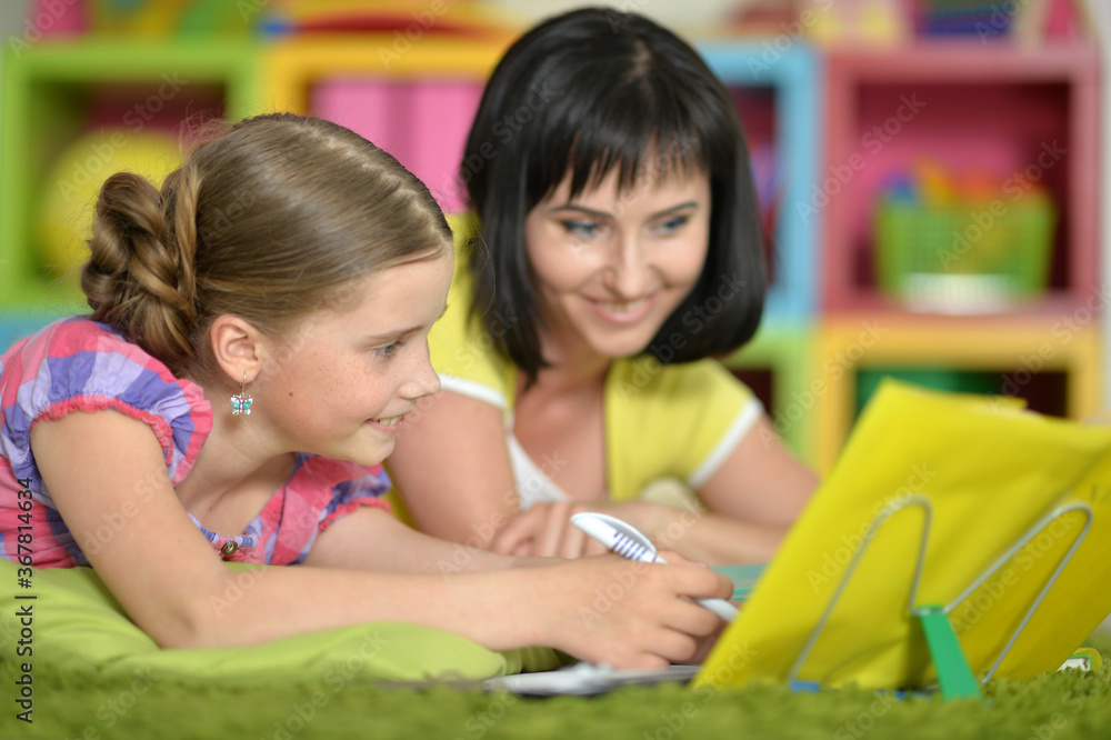 Cute girl and mother doing homework at home Cute girl and mother doing homework at home