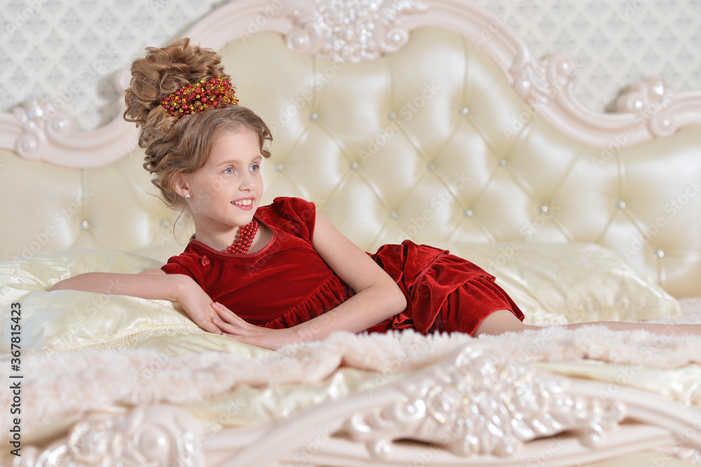 Cute girl in red dress lying on bed Cute girl in red dress lying on bed