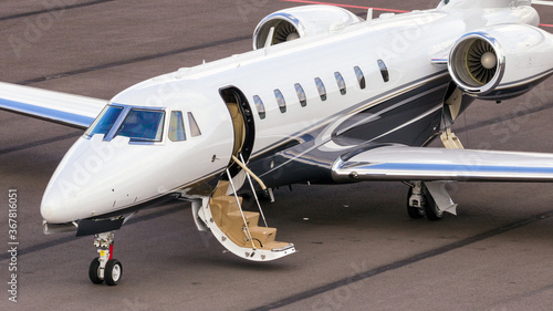 Foto Business jet on the tarmac of an airport with open airstairs