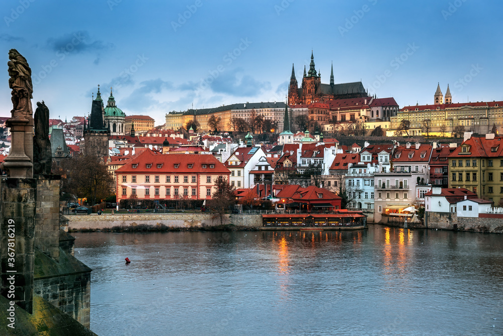 Illuminated Lesser town view from Charles Bridge in the evening, with Prague castle and Saint Nicholas church in Prague, Czechia