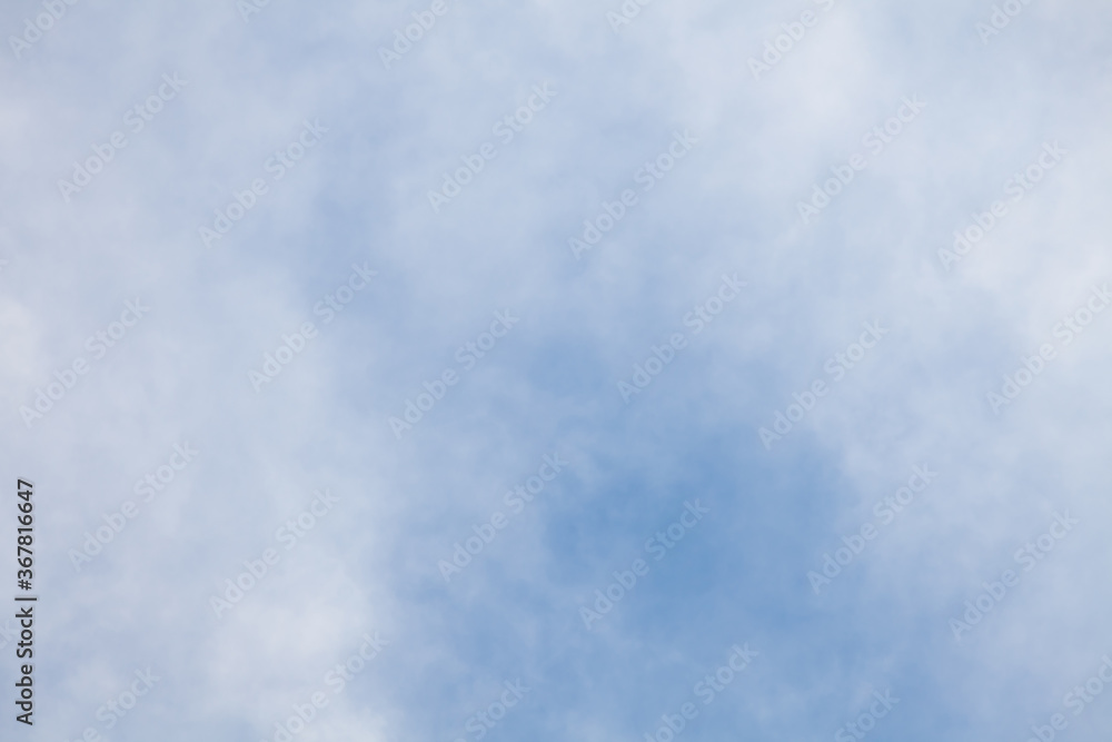 Close-up clear blue sky with transparent white clouds on a summer day, ozone layer pollution, background for wallpaper or banner.