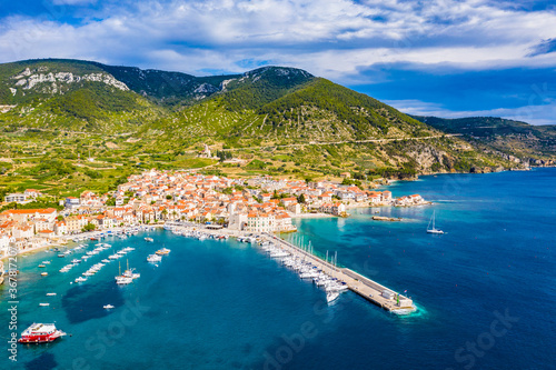 Fototapeta Naklejka Na Ścianę i Meble -  Aerial panoramic view of city Komiza - the one of numerous port towns in Croatia, is a lot of moored sailboats of a regatta