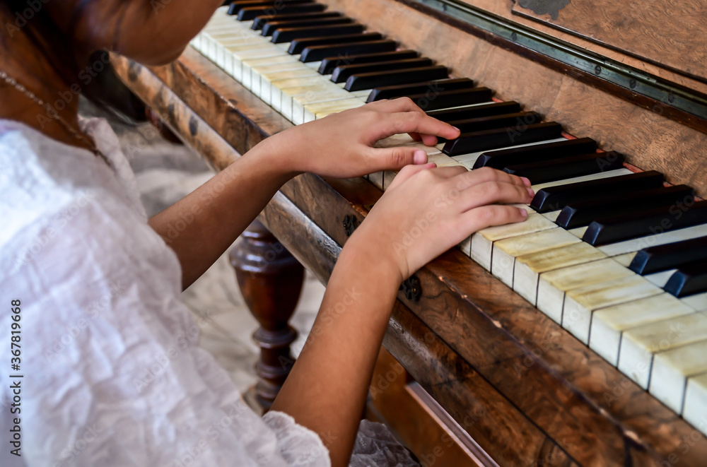 Fototapeta premium Hands of girl kid playing piano. Selective focus