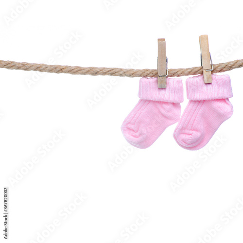 Pink baby socks on rope on white background isolation