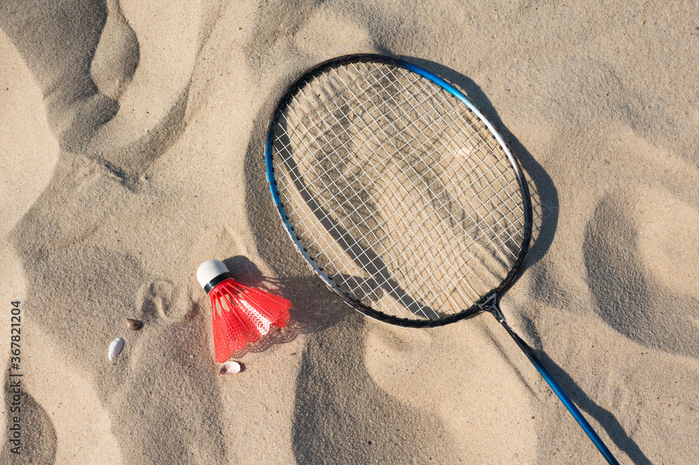 The concept of sports and active lifestyle. Racket and shuttlecock on the sand. View from above.