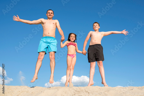 Happy family playing on the sand posing for the camera. Family games on vacation. Active rest, lifestyle.