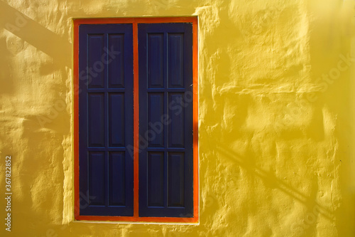 old wooden window in yellow wall