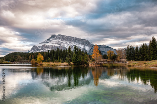 Cascade ponds with mount rundle and wooden bridge in autumn forest at Banff national park photo