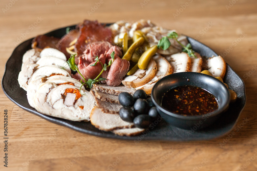 Meat plate. Cutting cold cuts. Grilled meat dinner. A dish of various types of meat and sausages