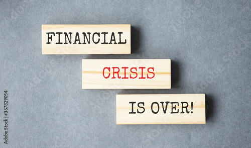 financial crisis is over text on wooden block