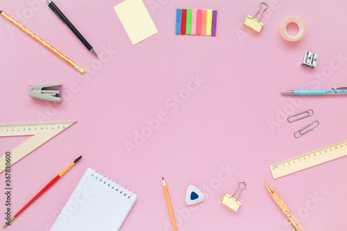Stationary, back to school,creativity and education concept. Notebook, pen, pencil, eraser, ruler, paper clips, stapler, brush on pink background, flat lay.