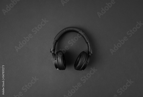 Black wireless headphones isolated on abstract dark background