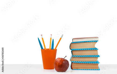 Back to school, pile of books and red apple on the white table with white background. Distance home education. Quarantine concept of stay home. © Inna