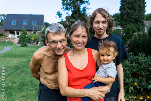 Baby girl with her grandfather, her mother and her uncle in the garden