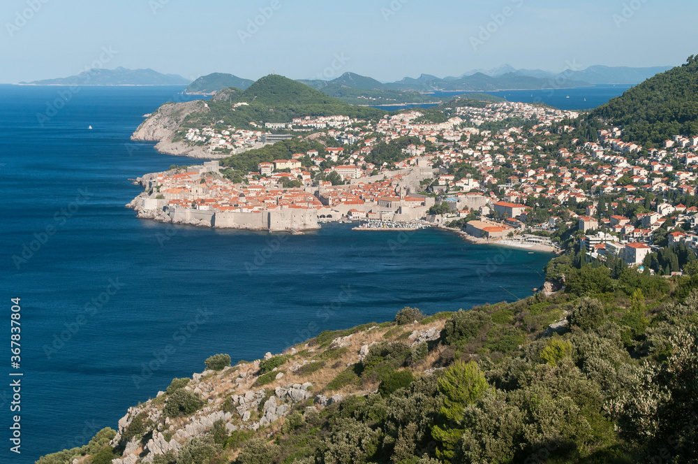 Old pier of Dubrovnik with surrounding mountains and sea.