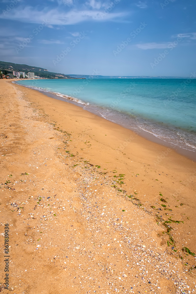 View of beautiful beach, blue sky and resort. Summer beach vacation / Sea waves on sand beach water and coast seascape View of beautiful beach, blue sky and resort. Summer beach vacation / Sea waves on sand beach water and coast seascape