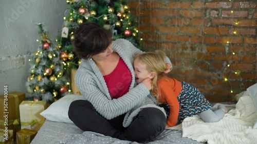 Mother and Daughter Having Fun on Christmas in Slow Mothion photo