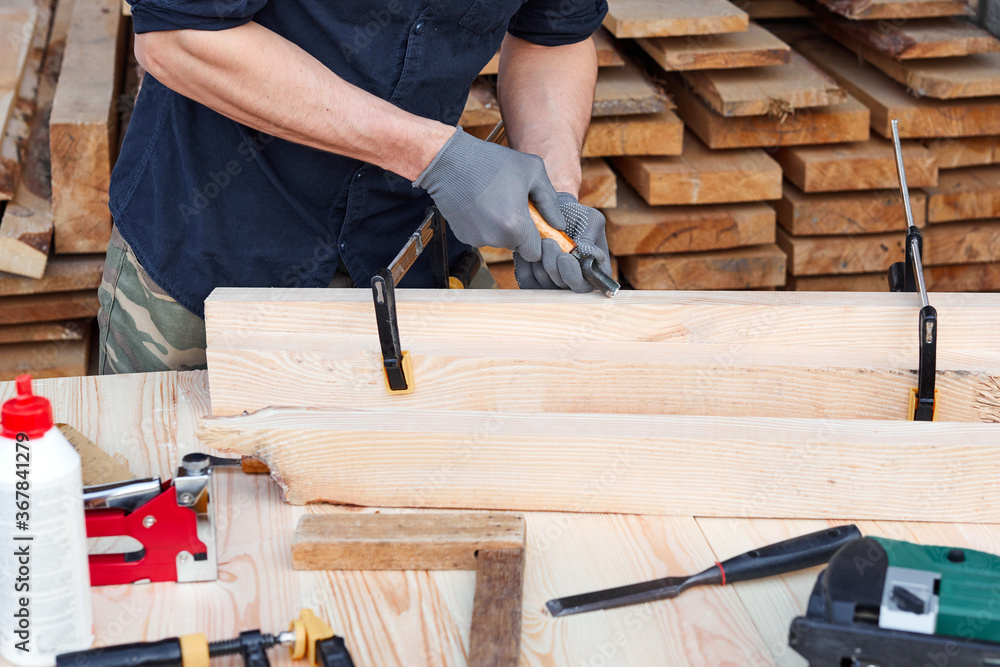 Male carpenter hands using instrument or equipment on a wooden table for handmade furniture. Close up. Male carpenter hands using instrument or equipment on a wooden table for handmade furniture. Close up.