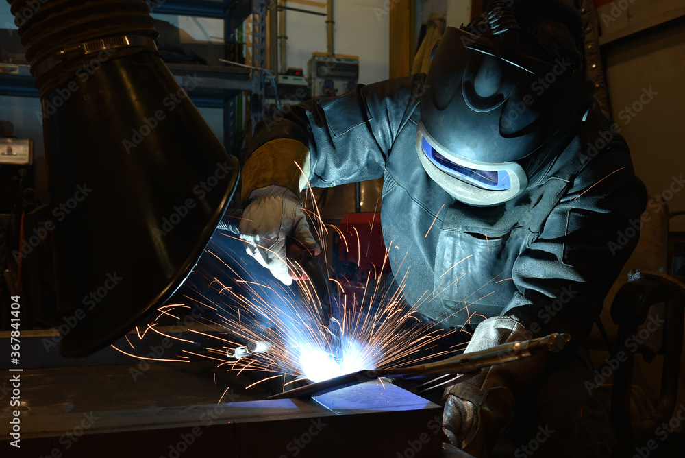 Industrial steel welder in factory technical, The welder is welding metal. Industrial steel welder in factory technical, The welder is welding metal.