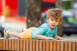 little boy of two years plays in a children's town in the summer. Children lifestyle