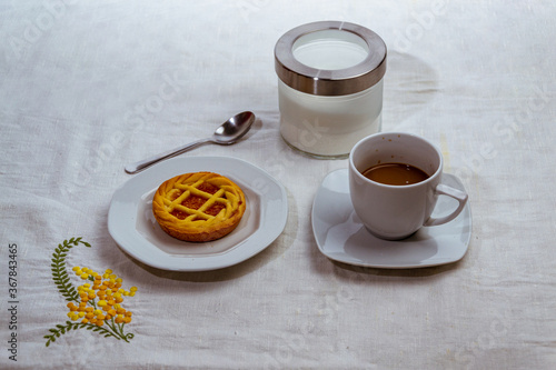 still life con taza de cafe y tarta de frutas sobre mantel blanco