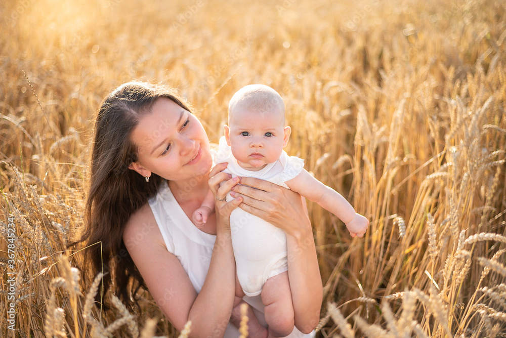 Beautiful young mother and her baby girl at the wheat field in sunny day, Czech republic Beautiful young mother and her baby girl at the wheat field in sunny day, Czech republic