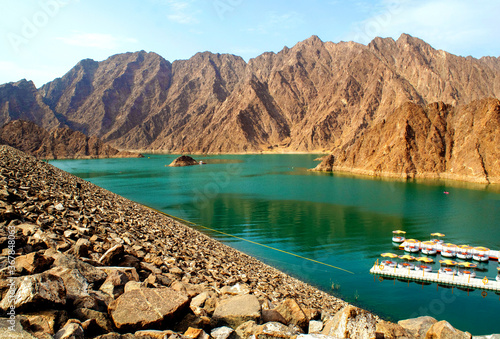Beautiful deep green Hatta lake between Hajar Mountains. Overview of Hatta dam in UAE. Picturesque natural lake and mountains