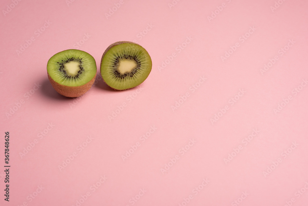 Kiwi halves over pink background Kiwi halves over pink background