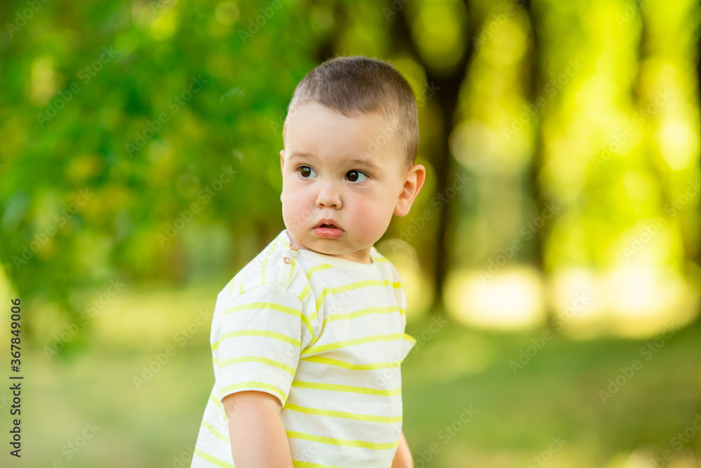 baby boy one year smiles in the summer on a walk in the park. Children's Lifestyle baby boy one year smiles in the summer on a walk in the park. Children's Lifestyle
