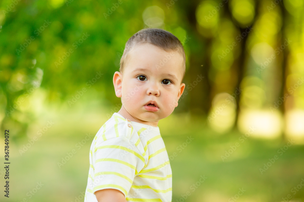 baby boy one year smiles in the summer on a walk in the park. Children's Lifestyle baby boy one year smiles in the summer on a walk in the park. Children's Lifestyle