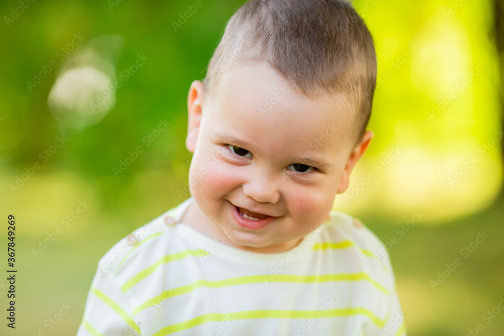 baby boy one year smiles in the summer on a walk in the park. Children's Lifestyle baby boy one year smiles in the summer on a walk in the park. Children's Lifestyle