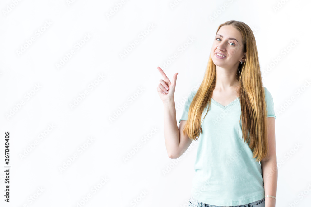 Portrait of a smiling girl standing and pointing one hand to the side on a white background Portrait of a smiling girl standing and pointing one hand to the side on a white background