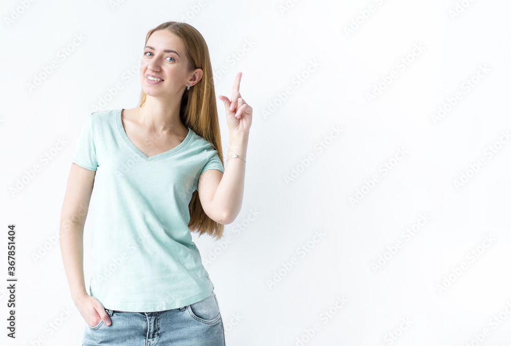 Portrait of a smiling girl standing and pointing one hand to the side on a white background Portrait of a smiling girl standing and pointing one hand to the side on a white background