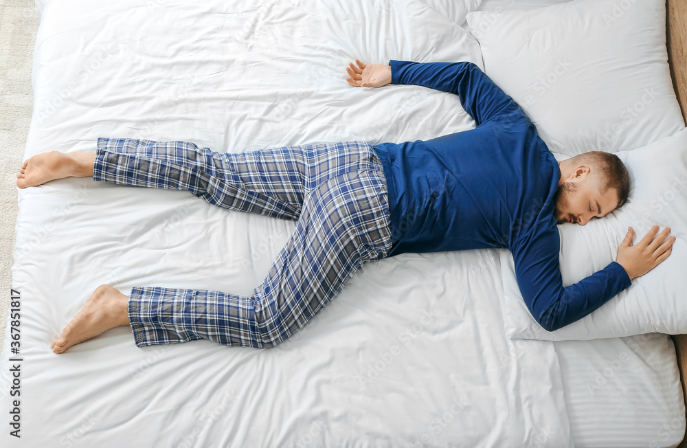 Young man sleeping in bed at home Young man sleeping in bed at home